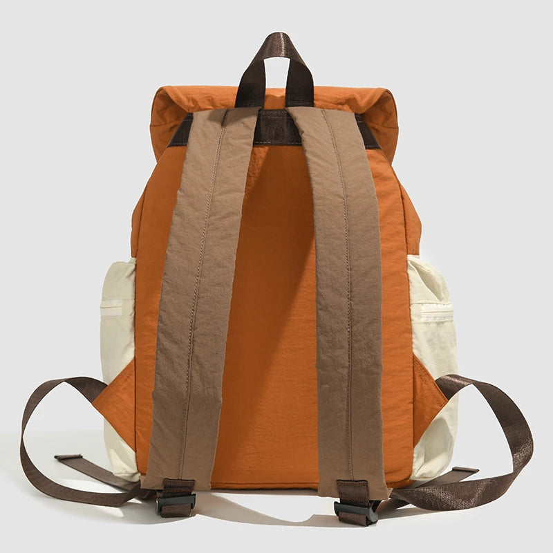 Orange and beige backpack with brown straps on a light gray background