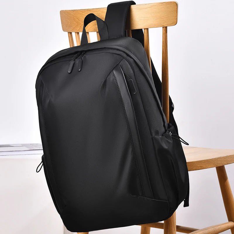 Black backpack on a wooden chair with a white background