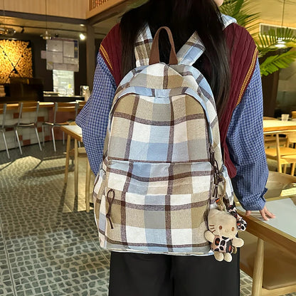 Person wearing a plaid backpack with a stuffed toy in an indoor setting