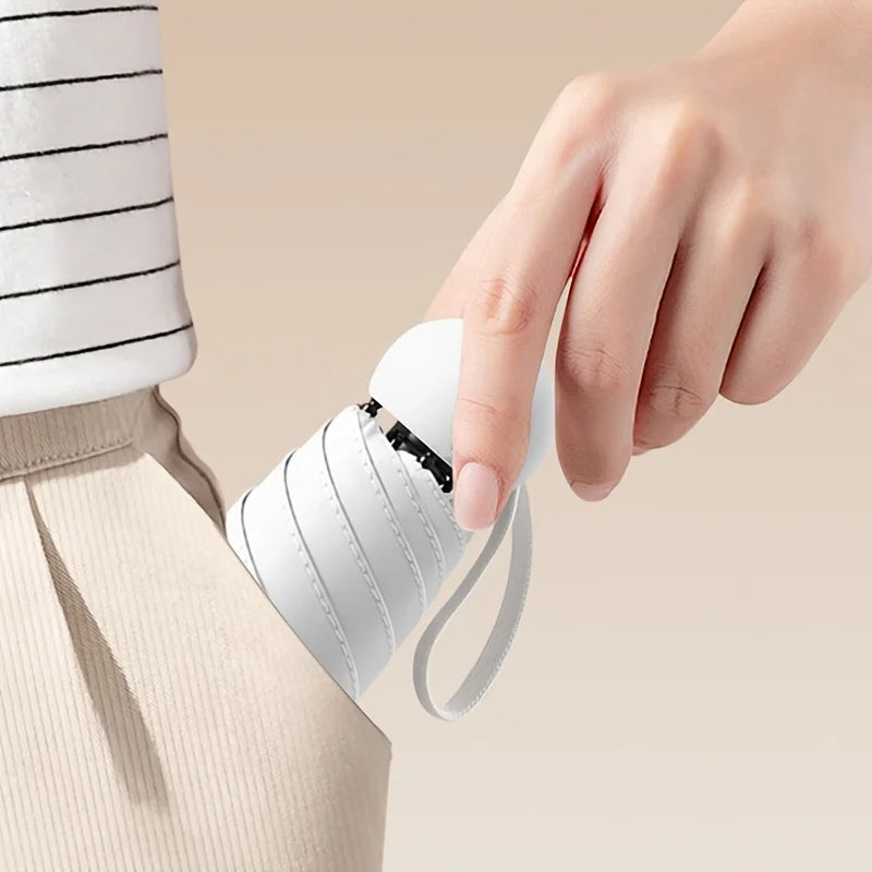 Person holding a small white umbrella with a beige background