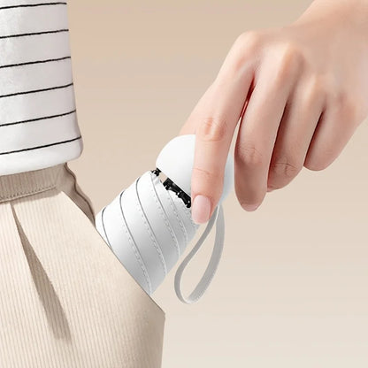 Person holding a small white umbrella with a beige background