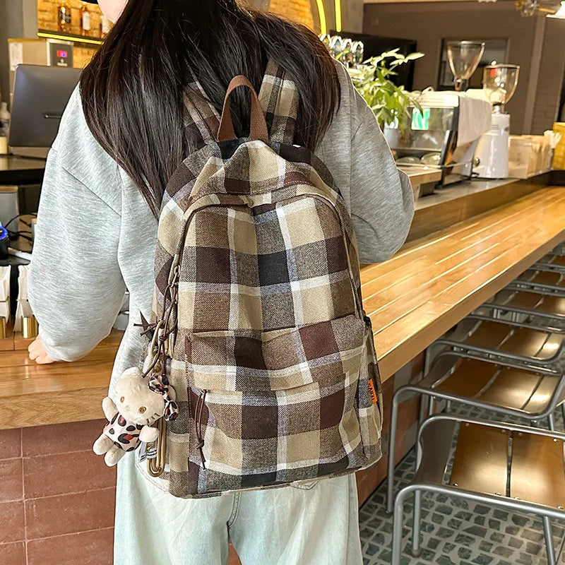 Person wearing a plaid backpack in a cafe setting