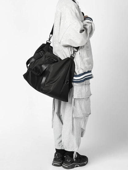 Person wearing a black bag and gray outfit on a white background