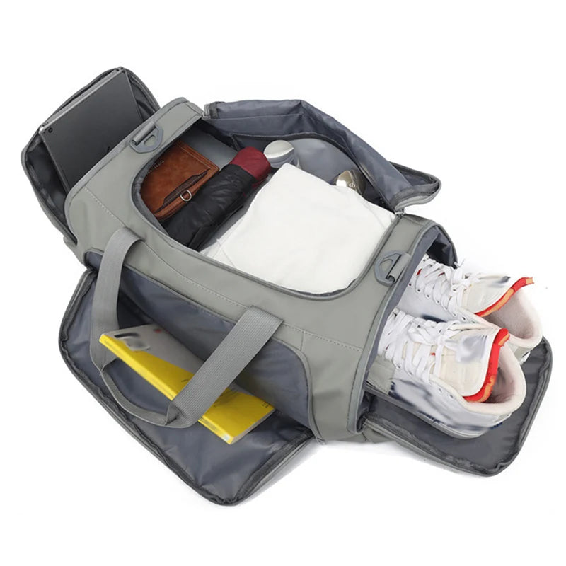 Open gray duffel bag with various items including shoes, a phone, and a yellow item on a white background.