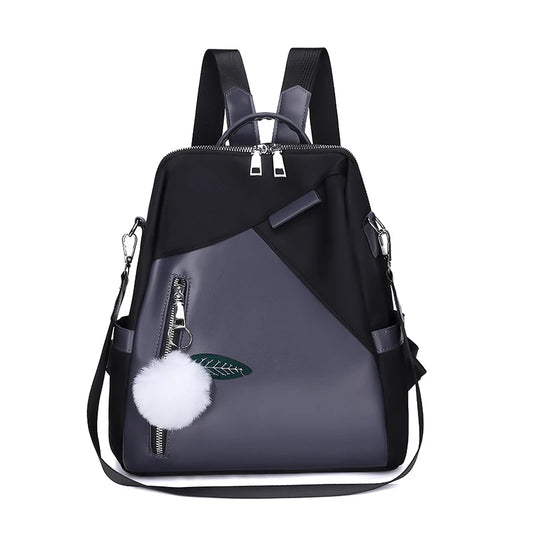 Black and gray backpack with a pom-pom and zipper detail on a white background