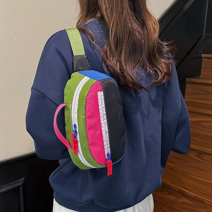 Person wearing a colorful mini backpack with a neutral background