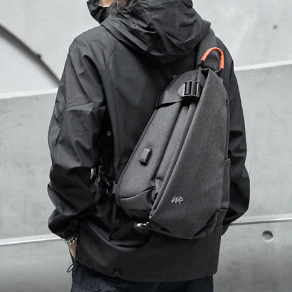 Person wearing a black jacket with a gray backpack against a gray background