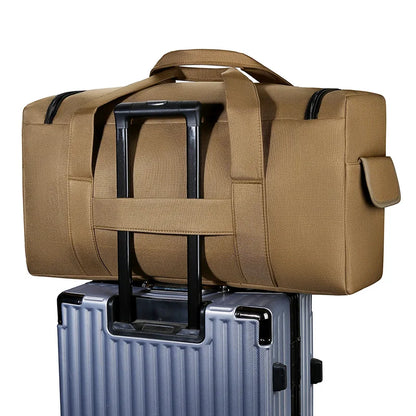 Brown duffel bag on top of a silver suitcase with a white background