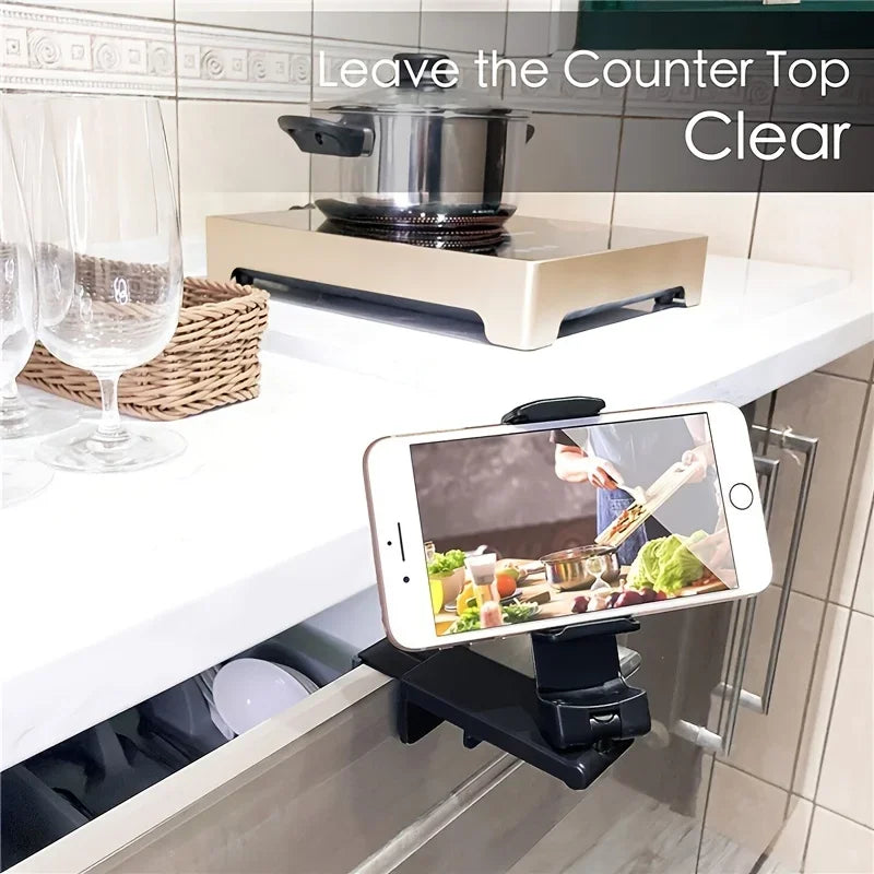 Kitchen counter with smartphone holder displaying a cooking video, text 'Leave the Counter Top Clear'.