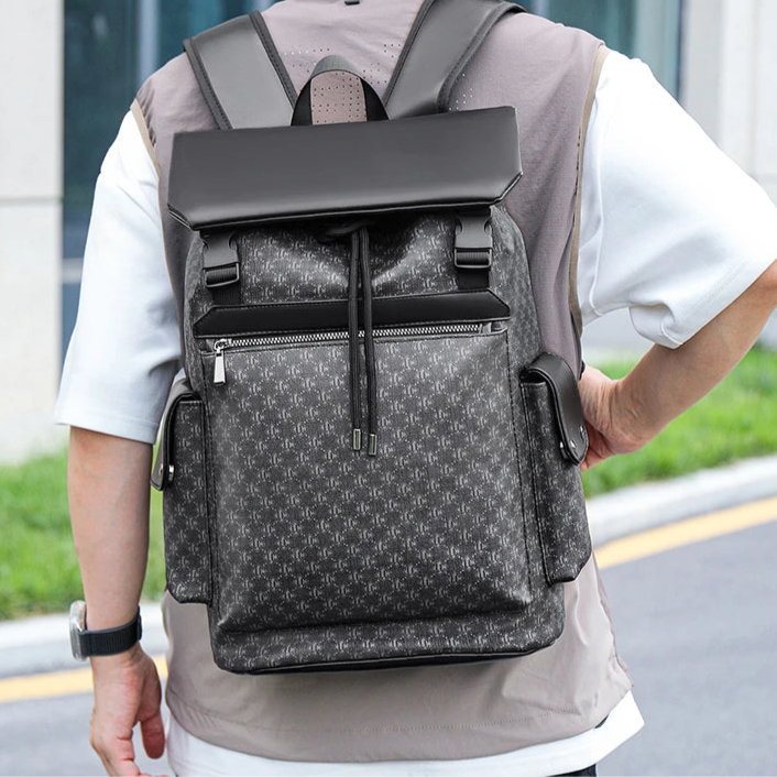 Person wearing a gray and black patterned backpack outdoors.