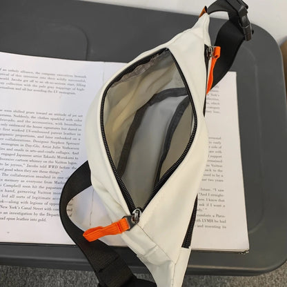 White crossbody bag with orange accents on a book