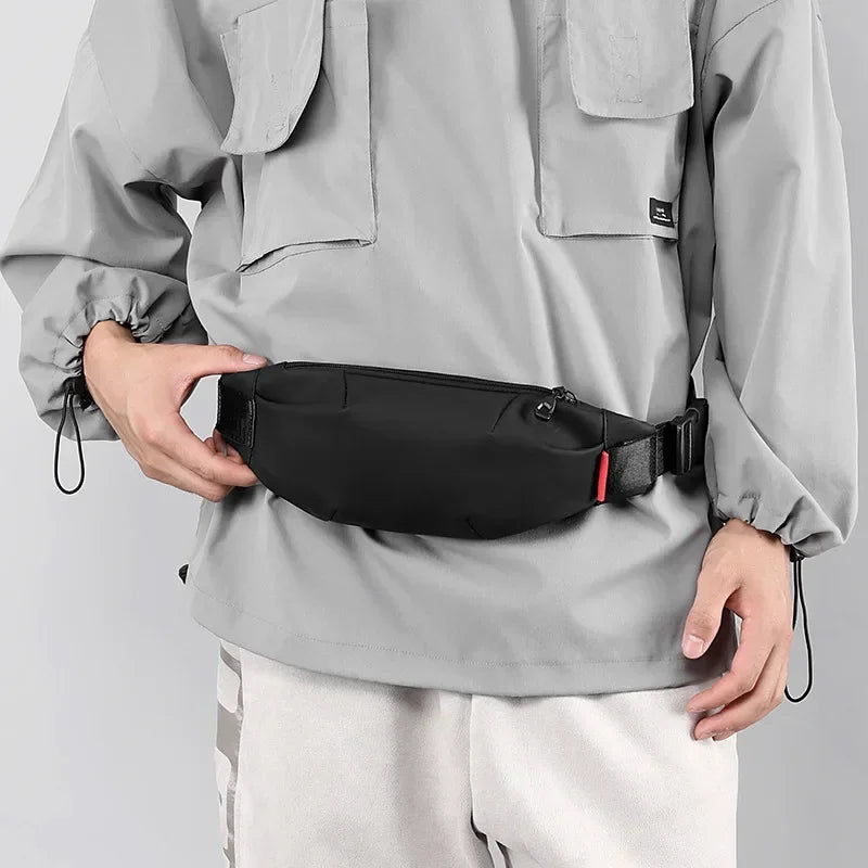 Person wearing a black waist bag with a neutral background