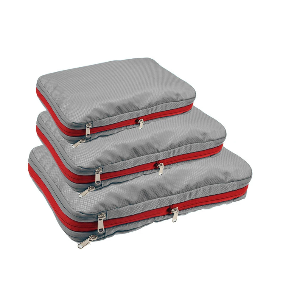 Three gray packing cubes with red zippers on a white background