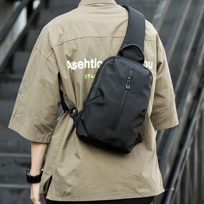 Person wearing a beige jacket with a black sling bag on a blurred background