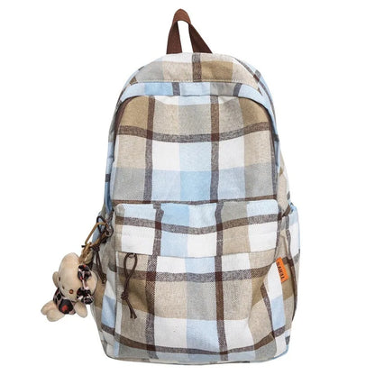 Plaid patterned backpack with a teddy bear charm on a white background