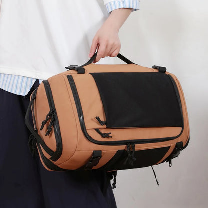 Person holding a brown and black duffel bag against a plain background