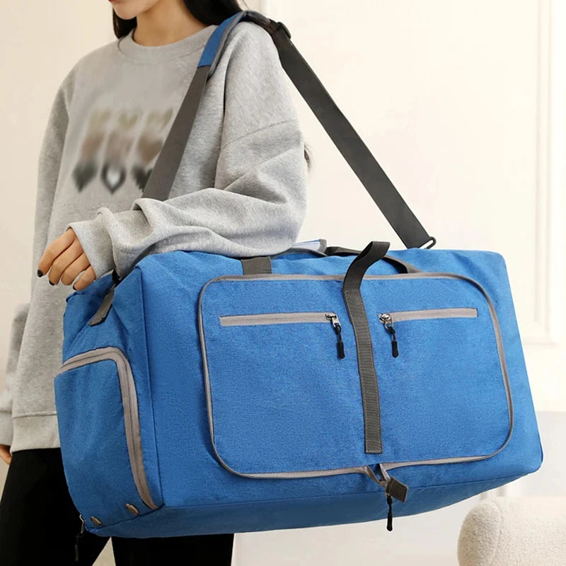 Person holding a blue duffel bag with gray accents