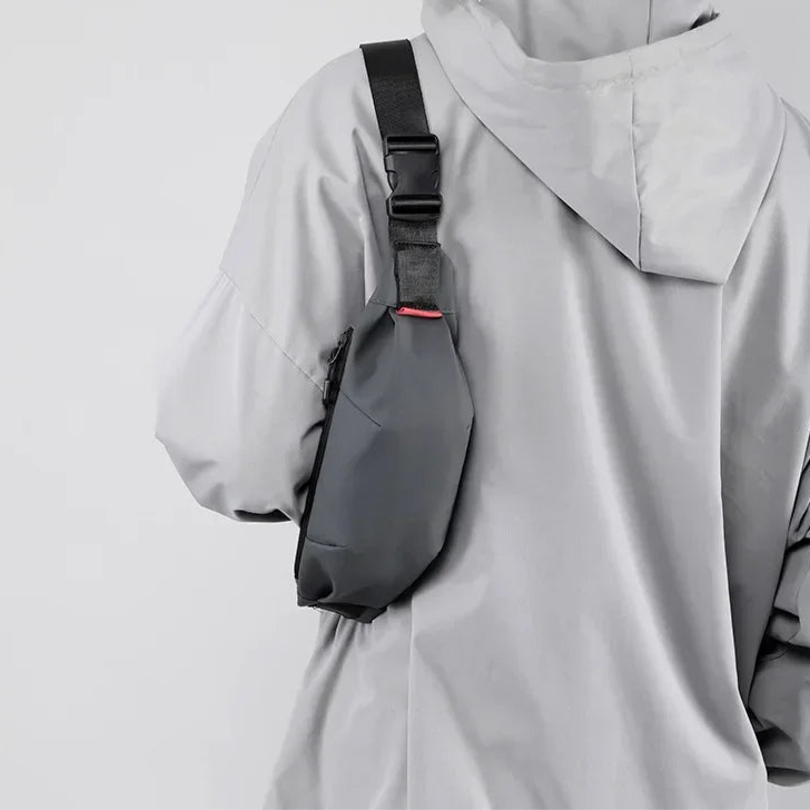 Person wearing a gray raincoat with a black backpack on a plain background