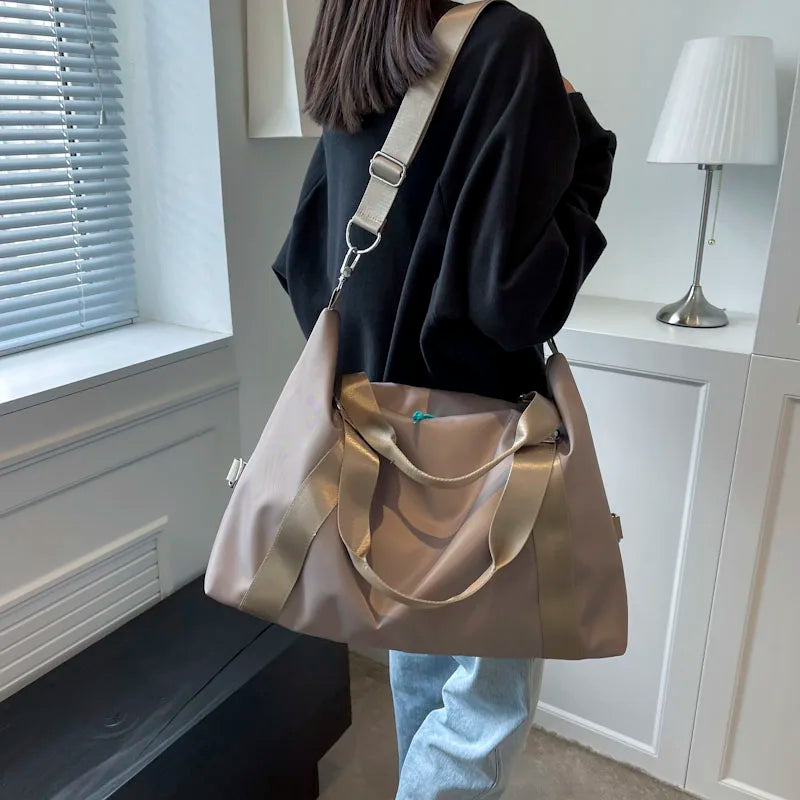 Person holding a gold handbag in a room with a window and lamp.