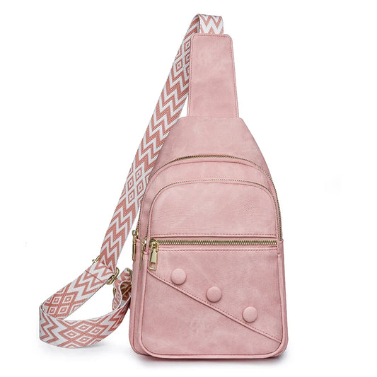 Pink suede sling bag with a patterned strap on a white background