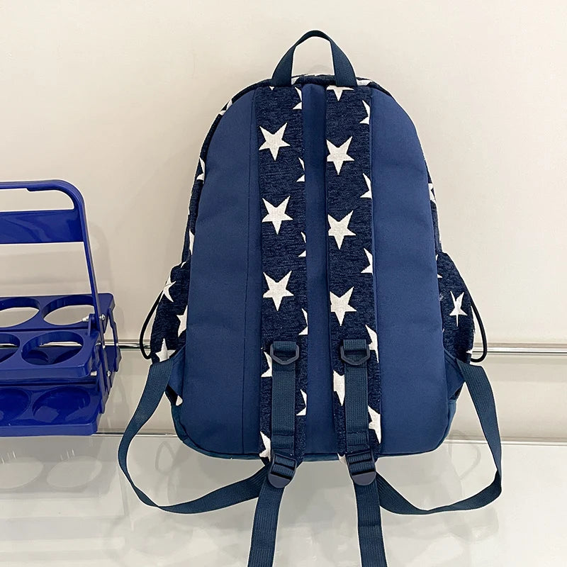 Navy blue backpack with white star pattern on a light gray background