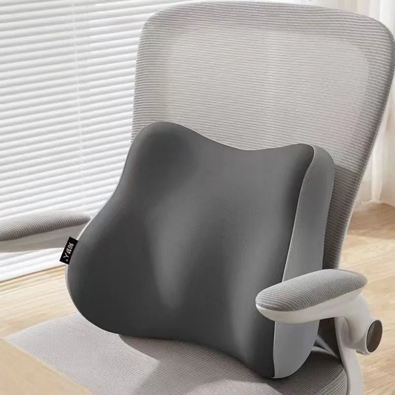 Gray office chair with a back support pillow in a home office setting.