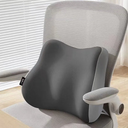 Gray office chair with a back support pillow in a home office setting.