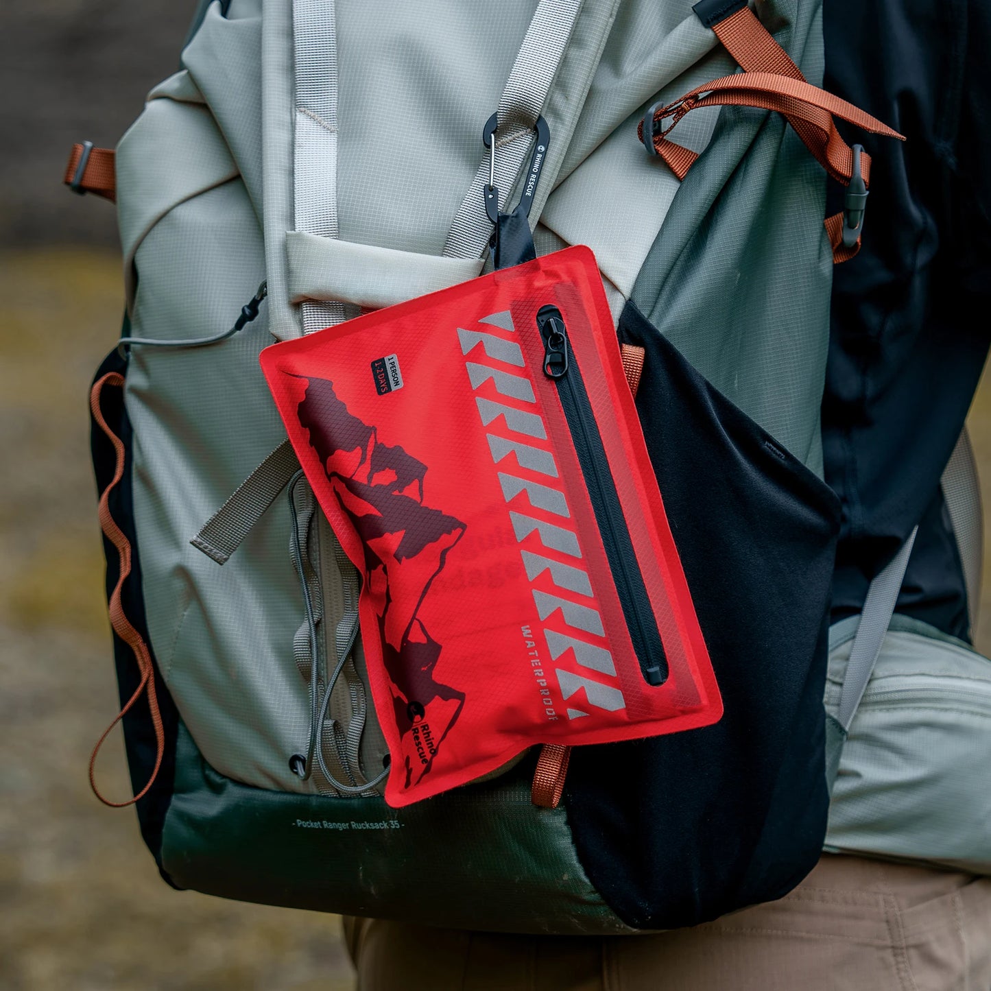 Red pouch with a logo attached to a backpack