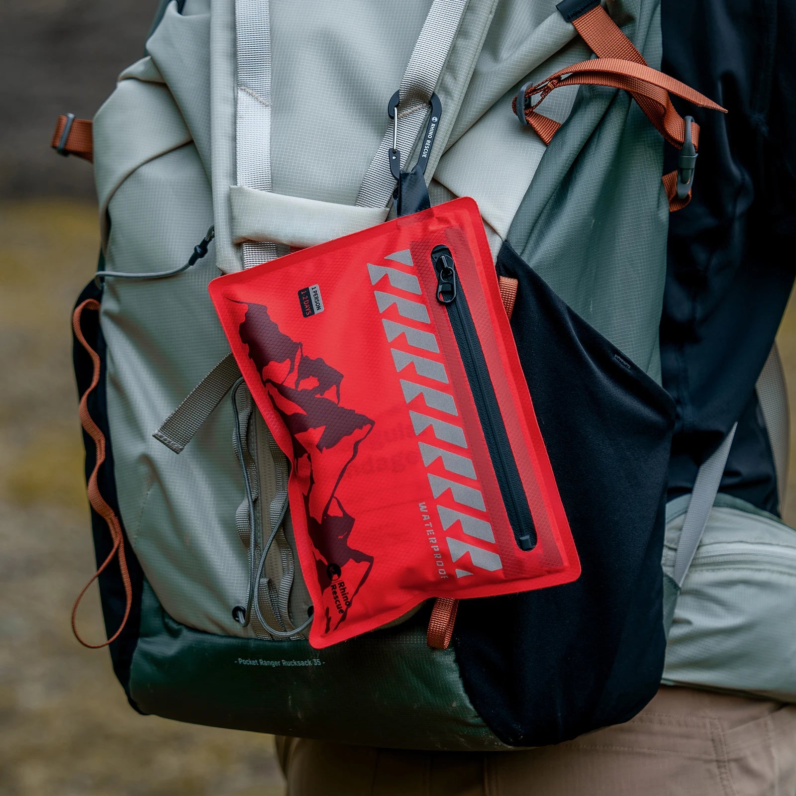 Red pouch with a logo attached to a backpack