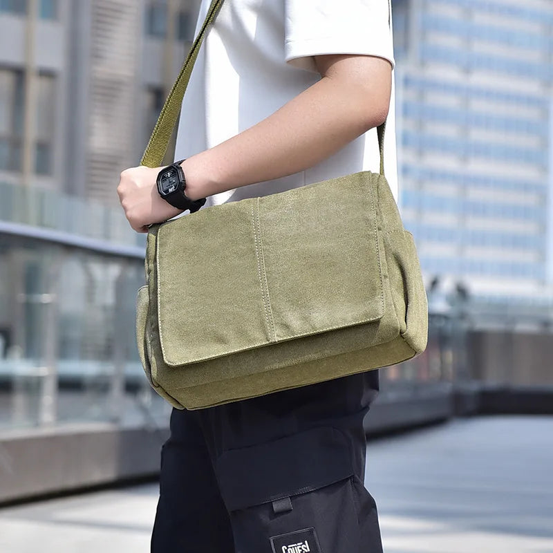 Person carrying a green shoulder bag with a blurred cityscape background