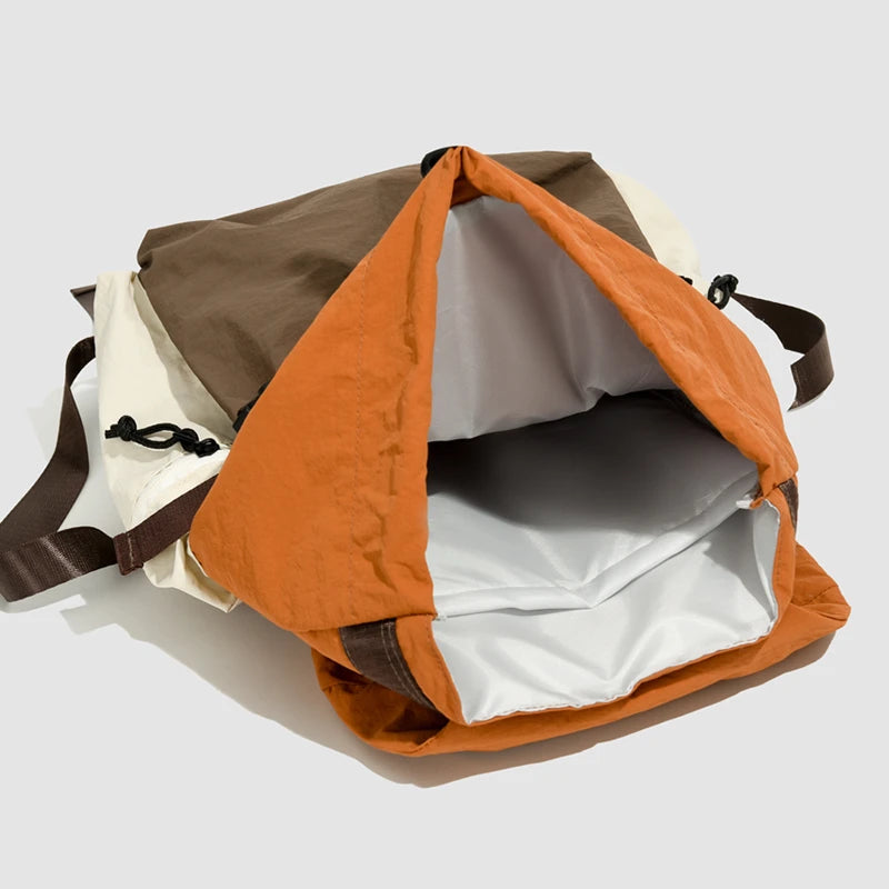 Multicolored backpack with orange flap on a light gray background