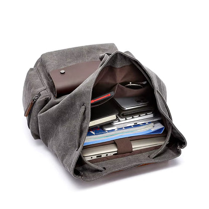 Gray backpack with compartments filled with items on a white background
