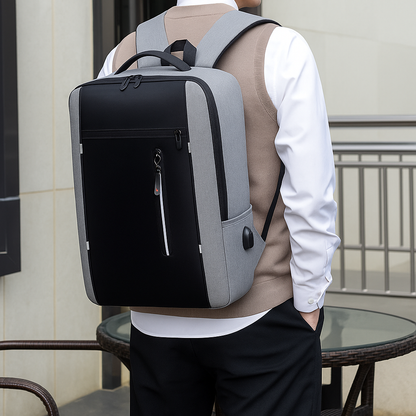 Person wearing a black and gray backpack outdoors.