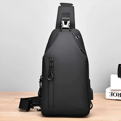 Black sling bag on a wooden surface with a light gray background