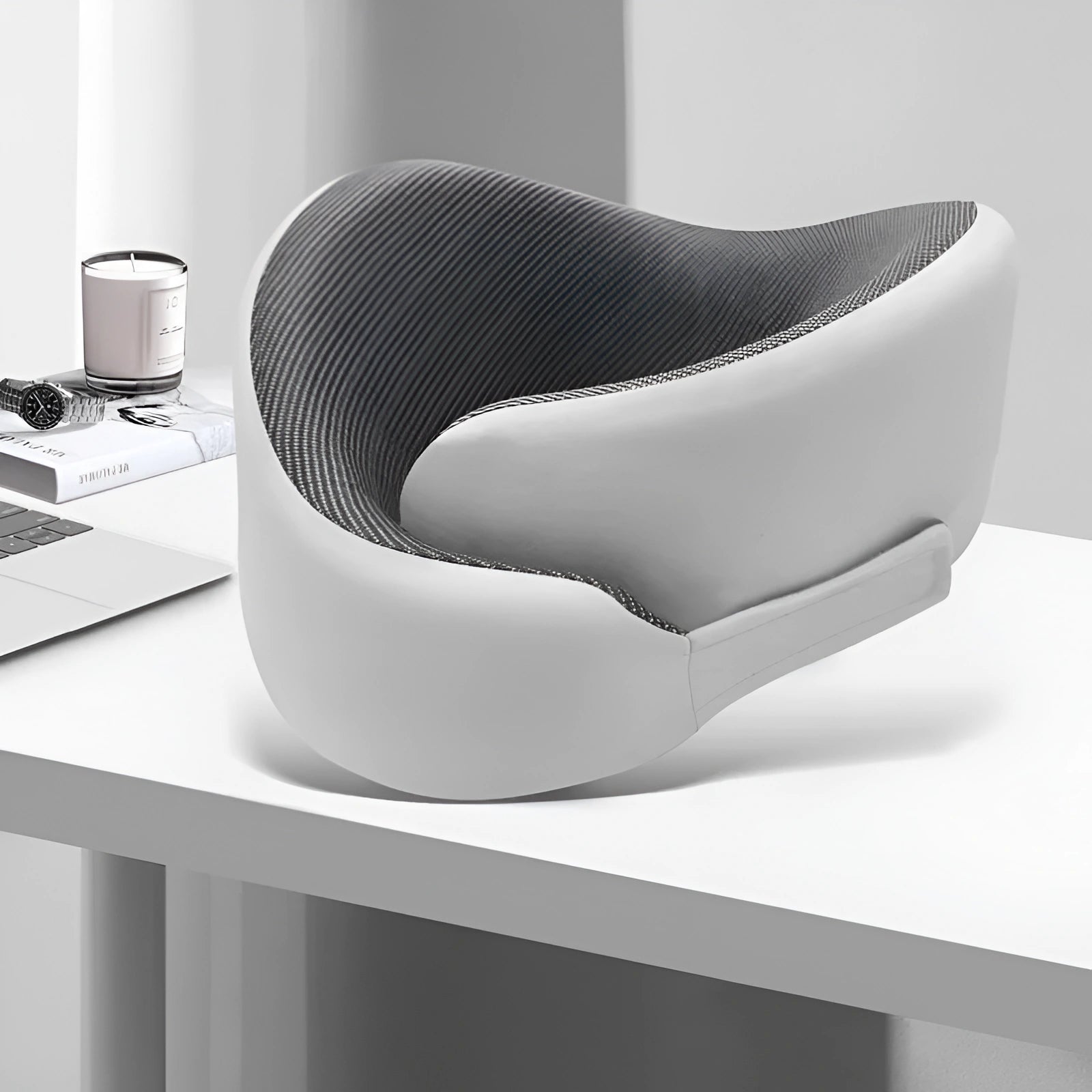 Modern gray and white office chair on a white desk with minimal decor.