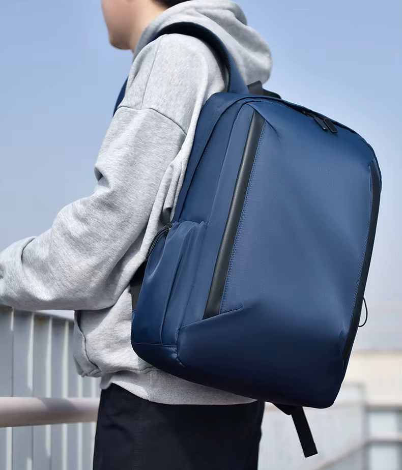 Person wearing a blue backpack with a clear sky background
